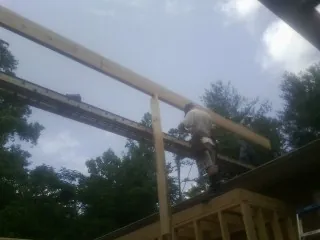 Carpenter setting a ridge beam over a new addition frame — Ice Dam Removal by Roofing Brothers in Blue River