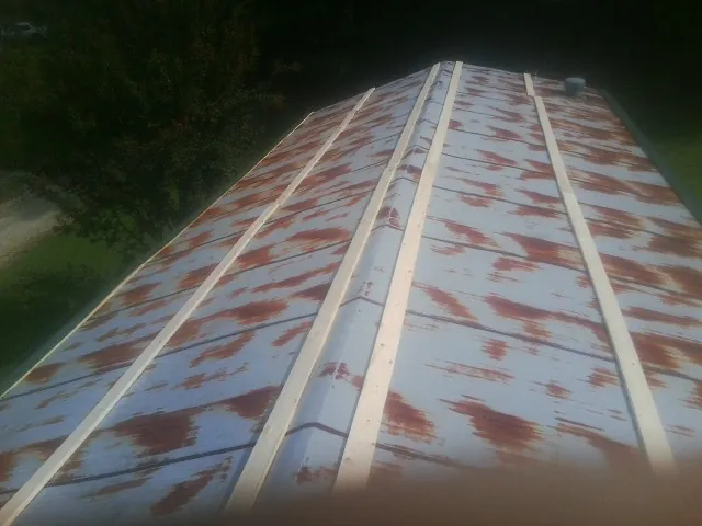 Rusted metal roof panels with new wood purlins before replacement — Storm Damage Roof Repair in Blue River by Roofing Brothers