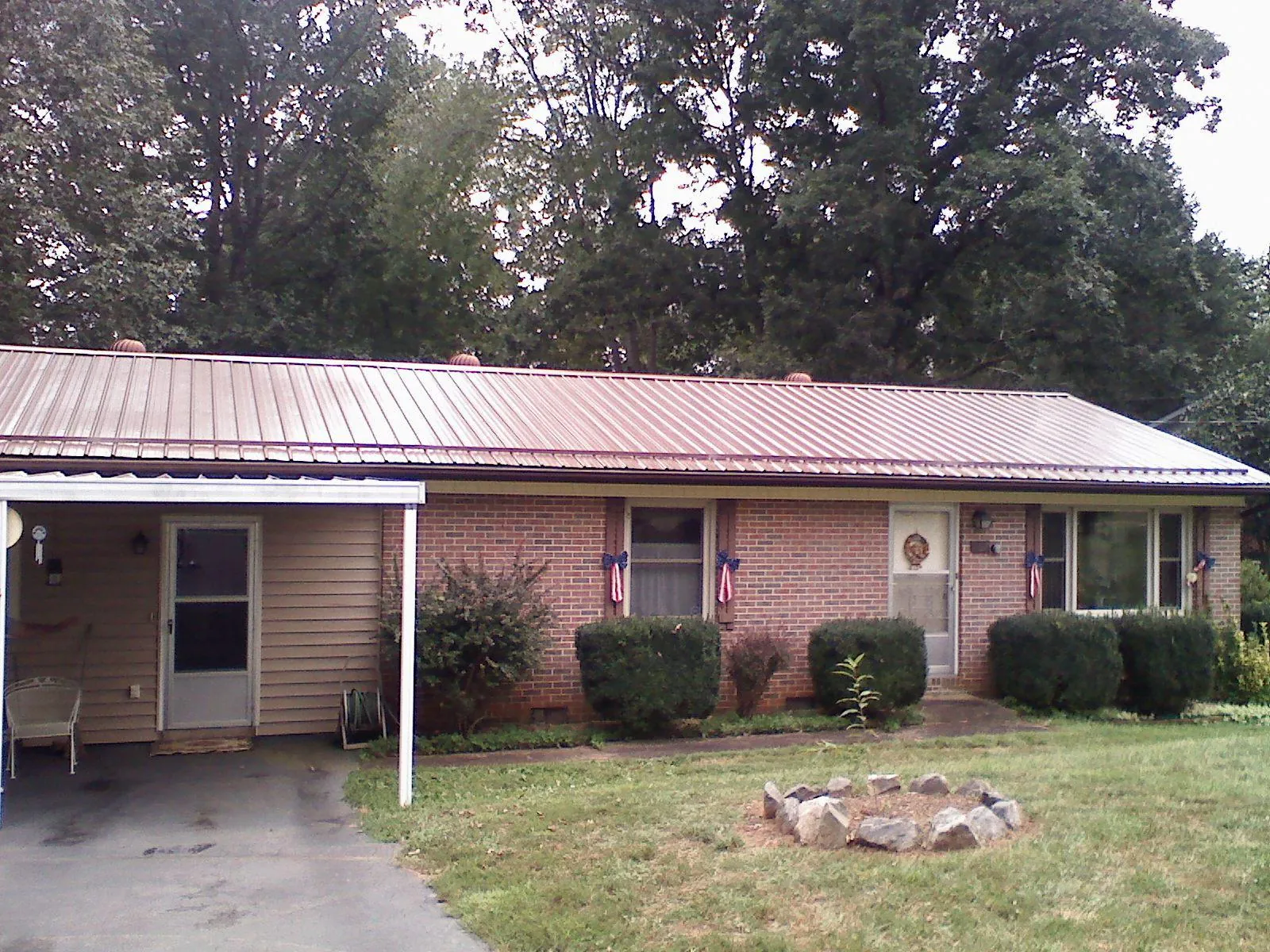 Bronze metal roof and carport on a brick ranch home — Roof Repair work by our crew in Blue River